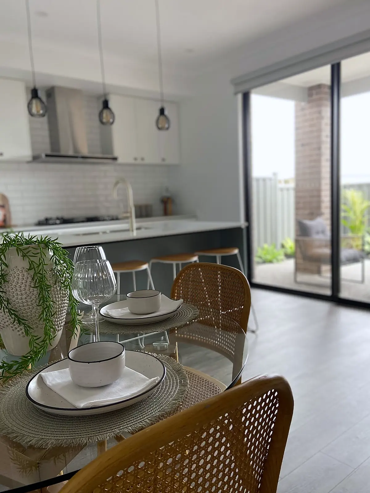 Meals area with rattan chairs looking out to the alfresco in a Truganina home