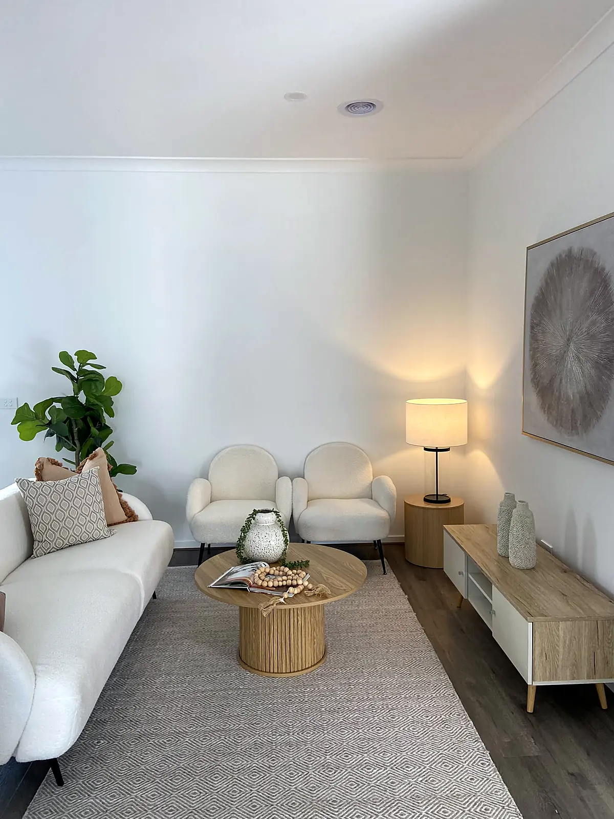 Front lounge staged with white sofa and armchairs in a Truganina home