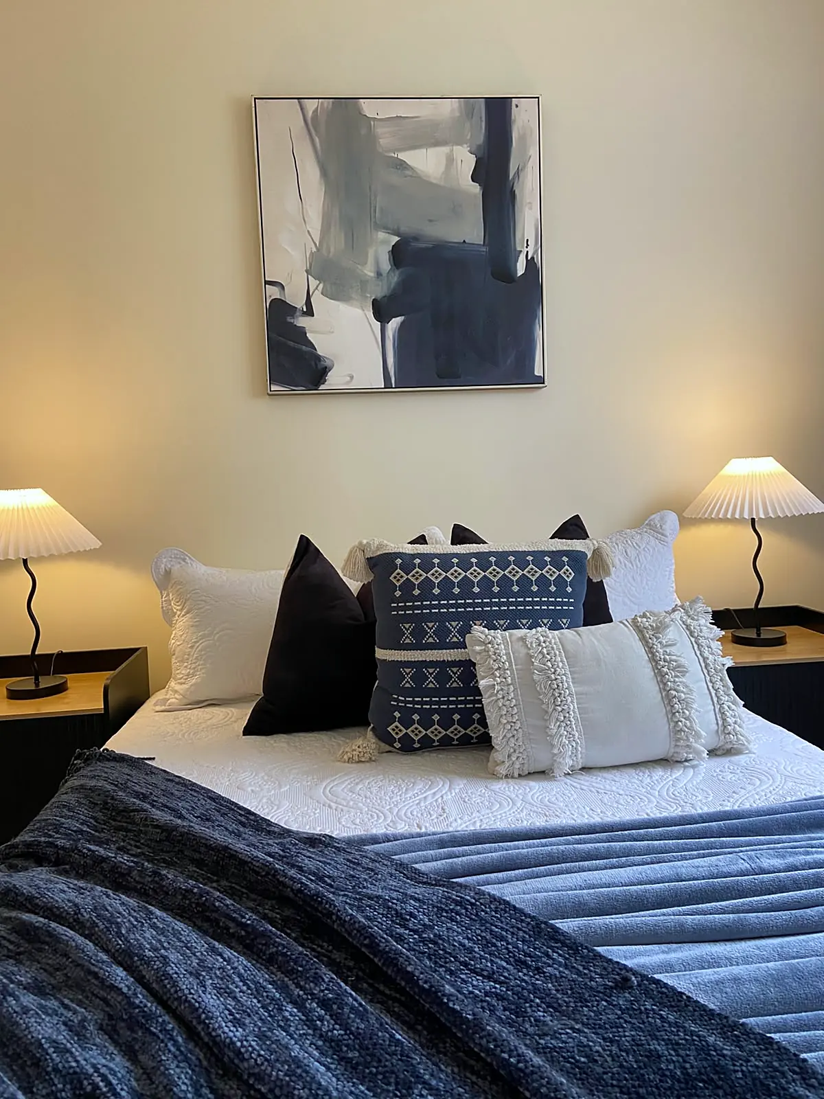 Bedroom staged with navy throw and abstract artwork in a Watsonia home
