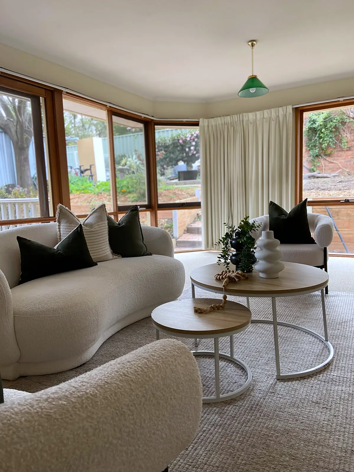 Staged living room with bay windows and curved sofa in a Watsonia home