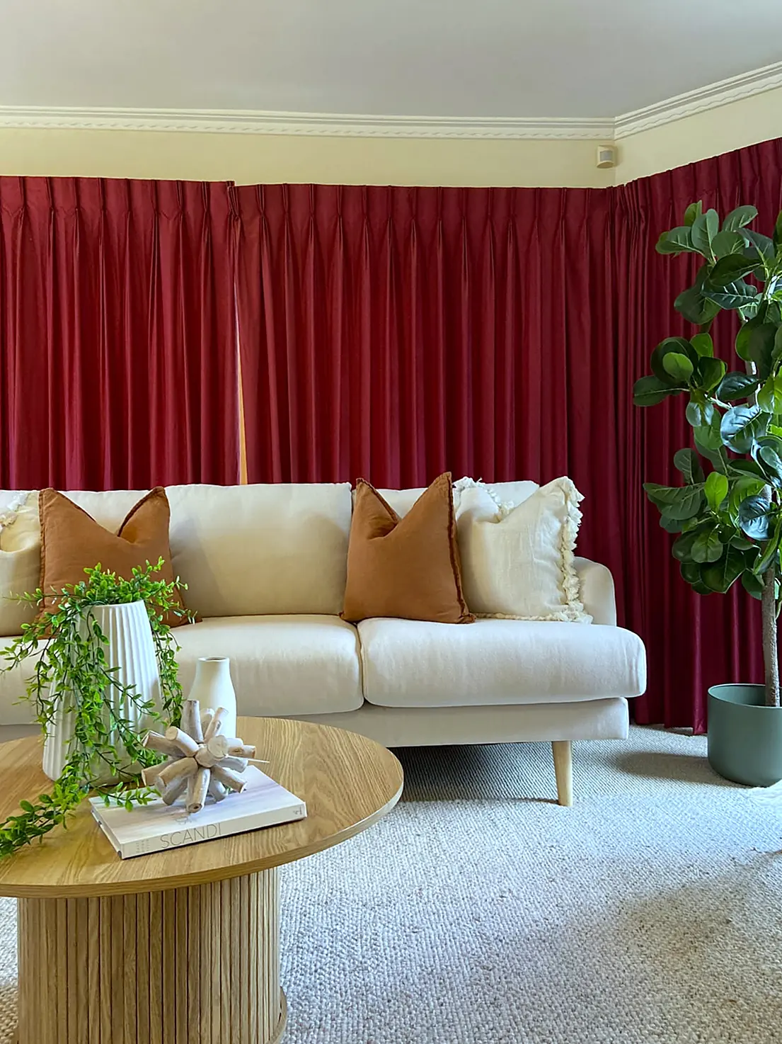 Lounge styled with cream sofa against red curtains in a Watsonia home