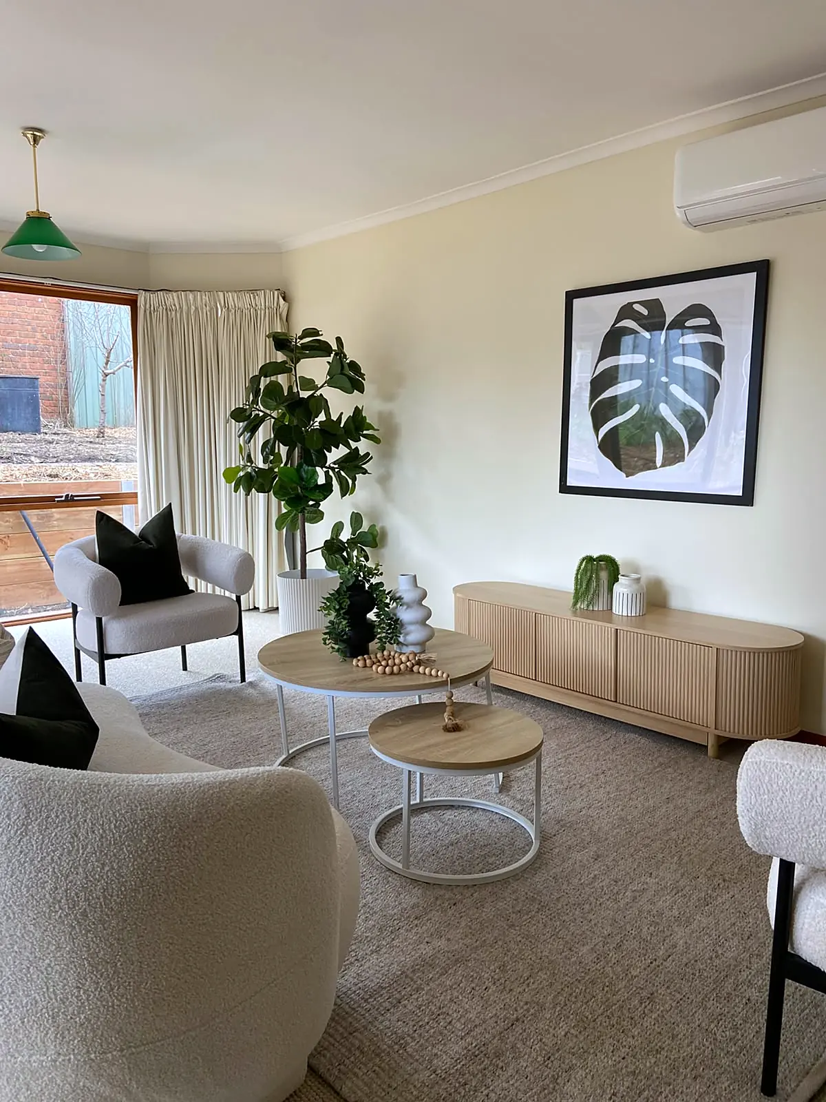 Family room staged with boucle armchairs and nest tables in a Watsonia home