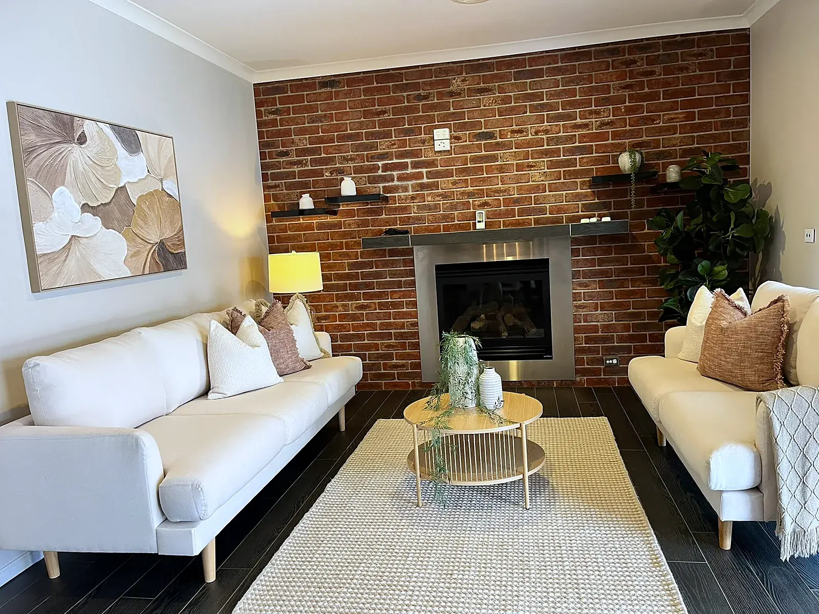 Staged living room with exposed brick fireplace in a Werribee home