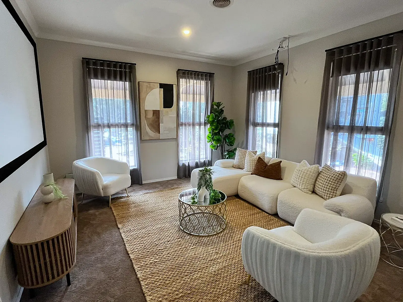 Rumpus room staged with curved sofa and jute rug in a Werribee home