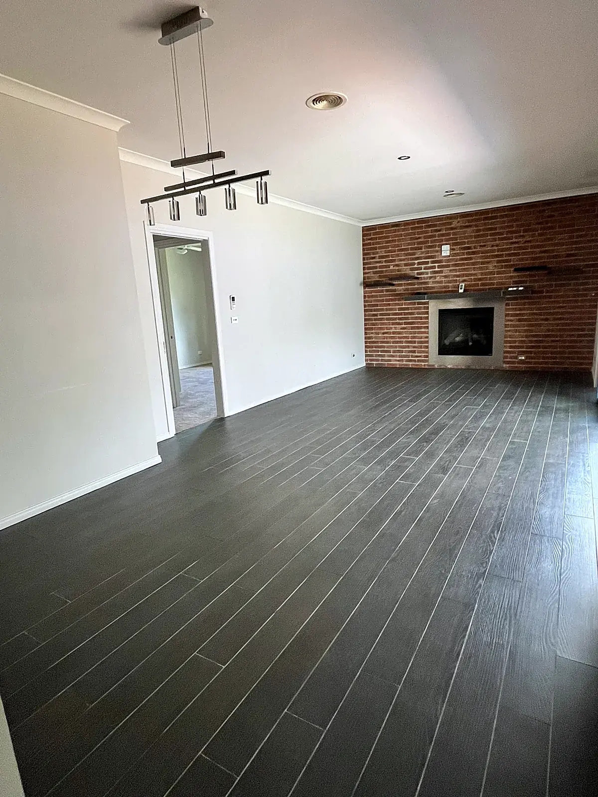 Empty living room with brick fireplace before staging in a Werribee home