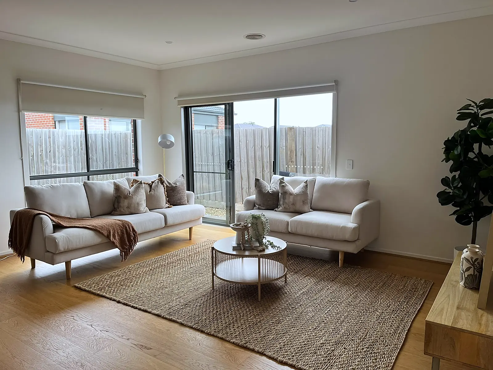Living room staged with linen sofas and jute rug on timber floors in a Wollert home