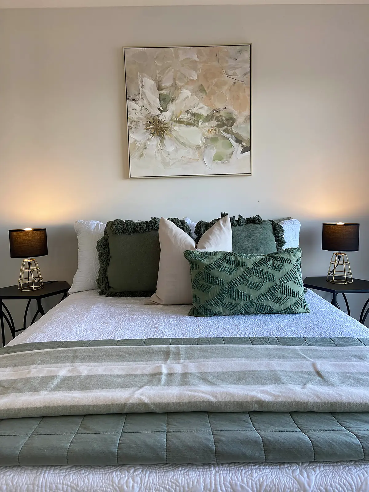 Bedroom staged with sage green cushions and floral artwork in a Wyndham Vale home