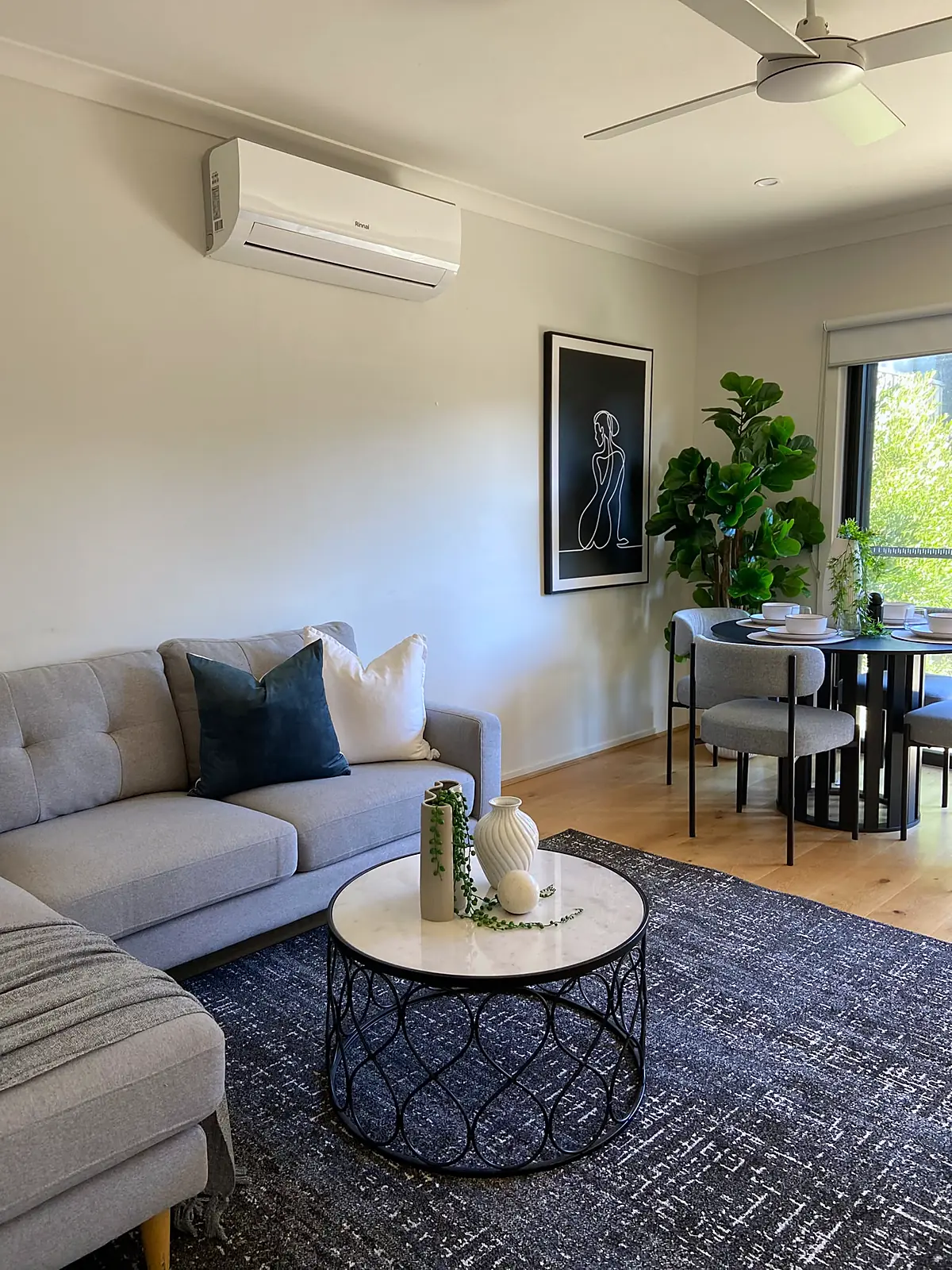 Living room staged with grey corner sofa and round coffee table in a Wyndham Vale home