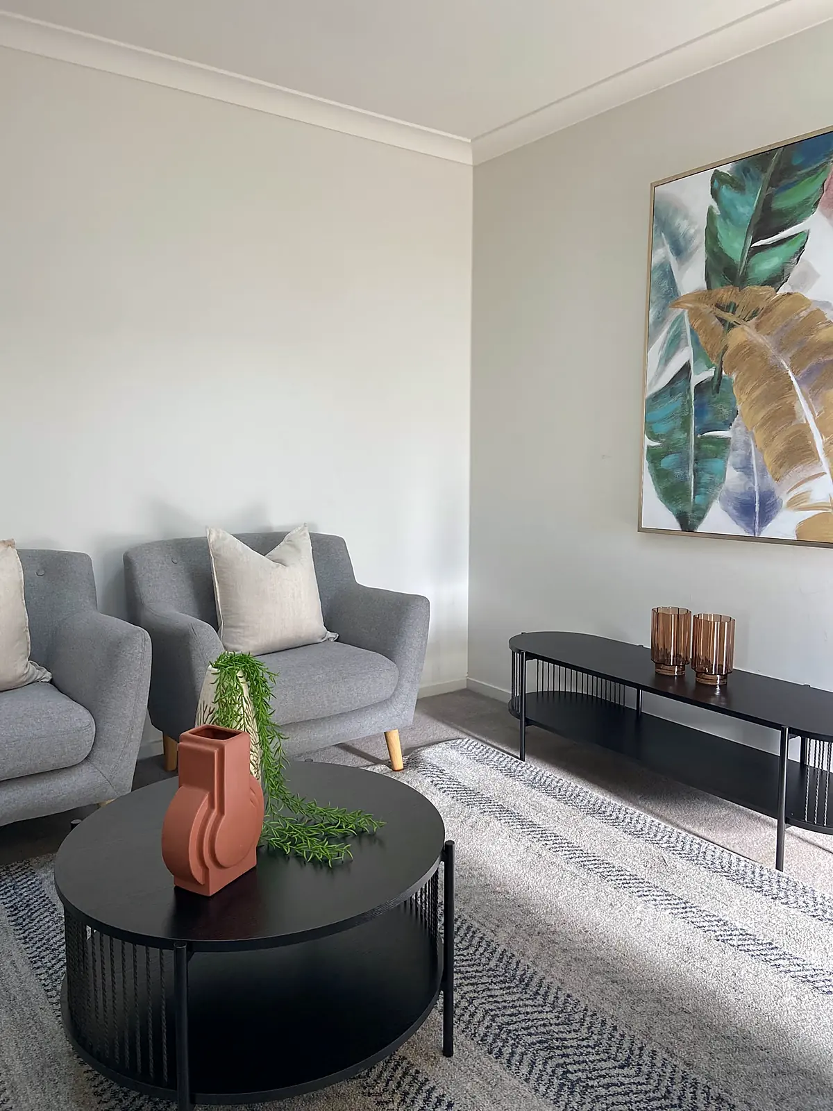 Second living area with armchairs, black console and botanical artwork in a staged Wyndham Vale home